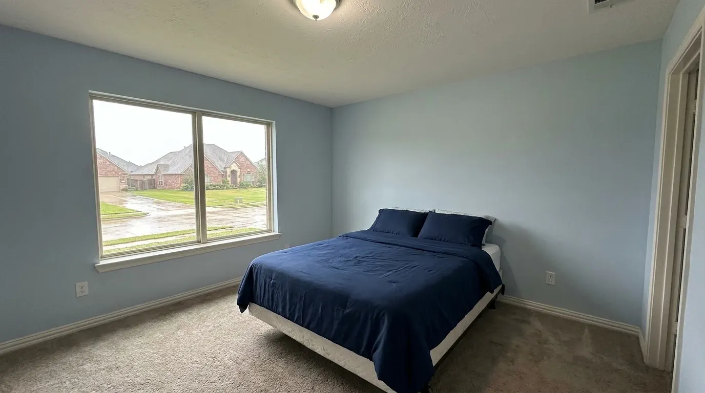 Same bedroom with rebuilt ceiling after storm damage restoration
